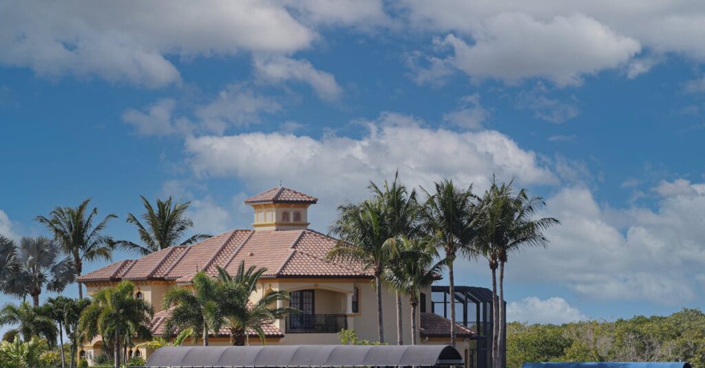 Beautiful waterfront home with boats and palm trees under clear skies in Cape Coral, Florida.