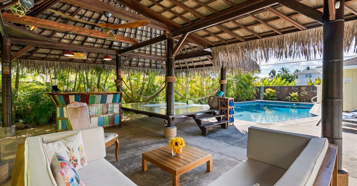 Tropical outdoor patio featuring a cabana, seating area, and swimming pool, perfect for luxury relaxation.