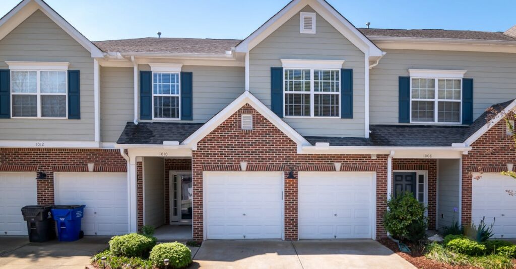 Modern suburban townhouses with garages in a quiet residential neighborhood.