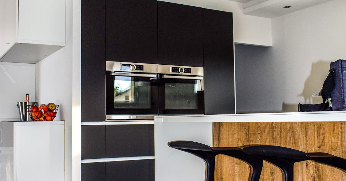 A contemporary kitchen featuring sleek cabinetry and elegant bar stools in a minimalist design.