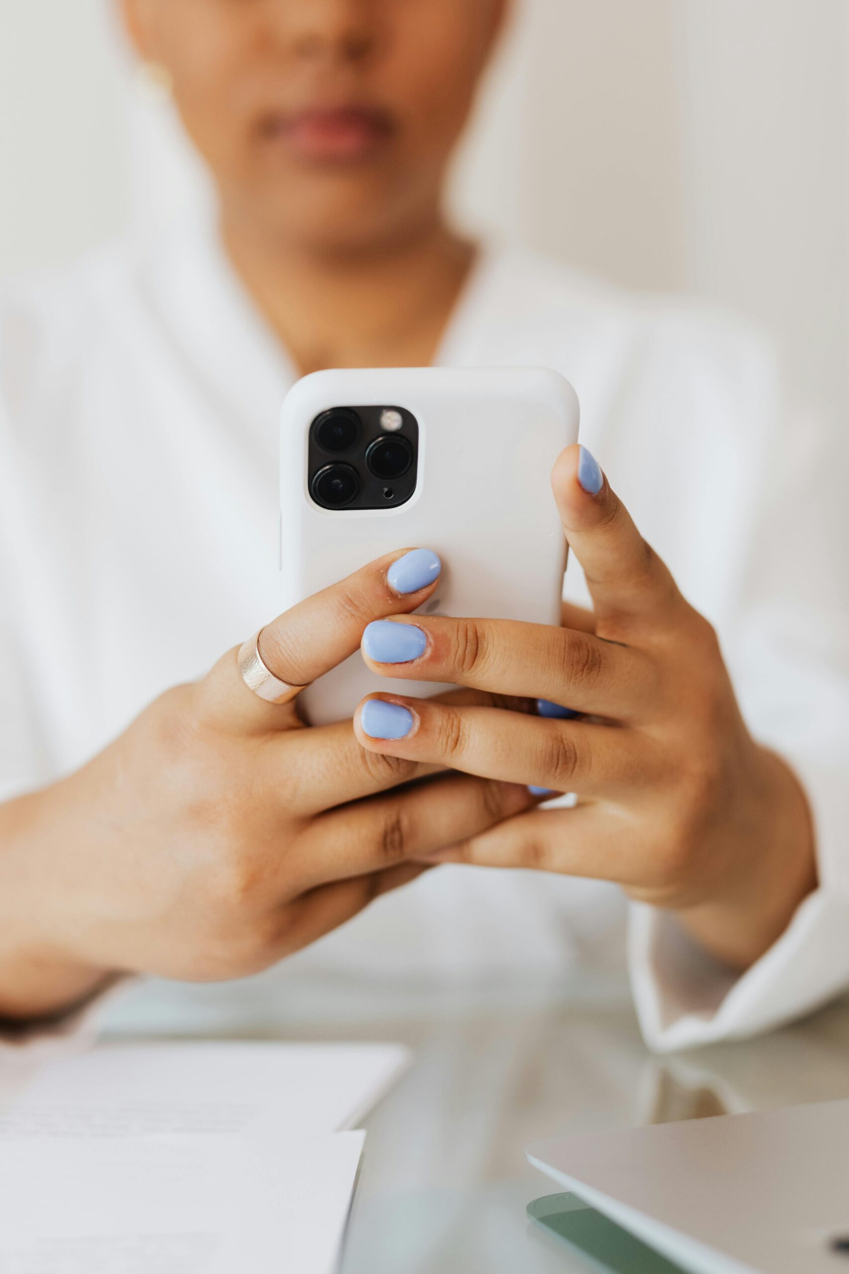 Close-up view of woman holding a smartphone indoors, showcasing modern technology.