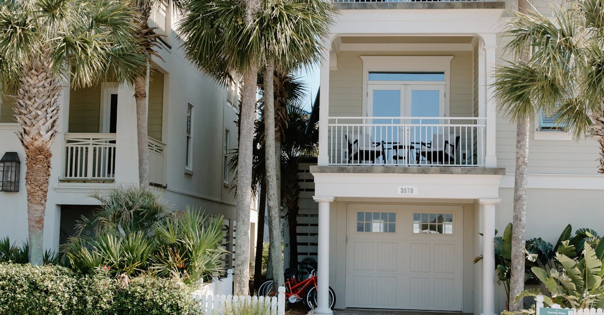 Charming three-story house with palm trees, ideal beachside living.